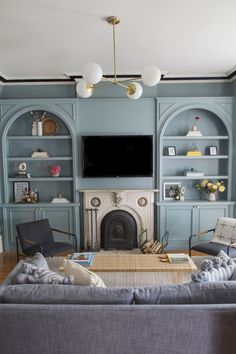 the living room is painted blue and has built in bookshelves with shelves on each side