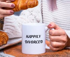 a woman is holding a croissant in her hand