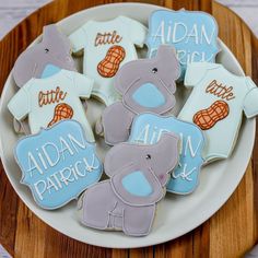 some cookies that are on a plate with blue and gray ones in the shape of elephants