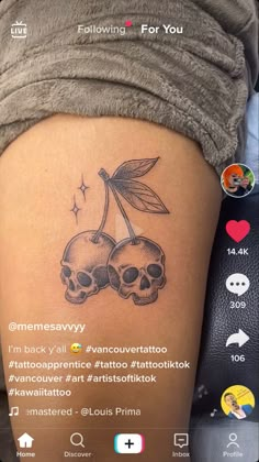 the back of a woman's thigh with two skulls and a leaf on it