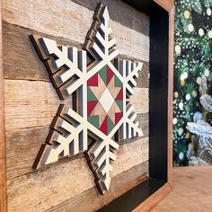 a wooden snowflake is hanging on the side of a wood paneled wall