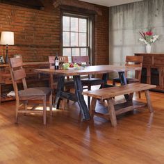 a wooden table with two benches in front of it and a brick wall behind it