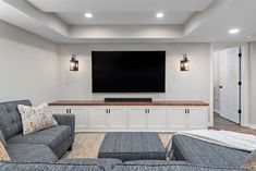 a living room filled with furniture and a flat screen tv mounted to the side of a wall