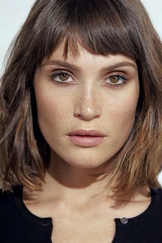 a close up of a person with a short haircut and brown eyeshadow