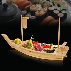 a wooden boat filled with lots of different types of sushi and other food items