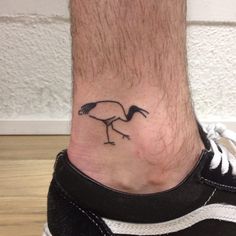 a foot with a bird tattoo on it