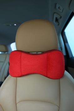 the back seat in a car with a red pillow on it's headrest