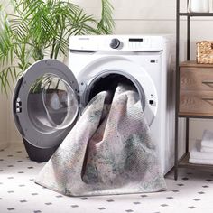 a washer and dryer sitting next to each other in a room with plants