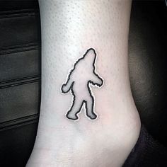 a bigfoot tattoo on the foot of a person