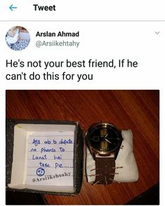 a watch sitting on top of a wooden table next to a notepad and pen