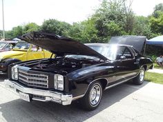 an old black car with its hood open