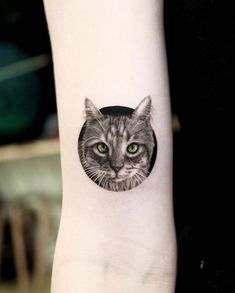 a cat's face with green eyes is shown on the wrist and it has a circular