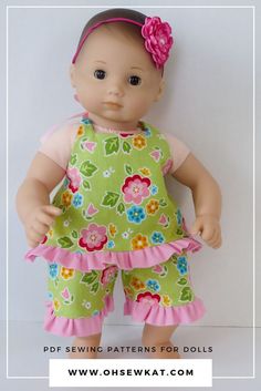 the doll is wearing a green dress with pink flowers on it