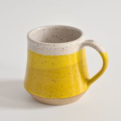 a yellow and white cup sitting on top of a table