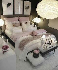 a white bed sitting in a bedroom next to two lamps and pictures on the wall