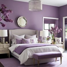 a bedroom with purple walls, white bedding and lots of flowers on the nightstands