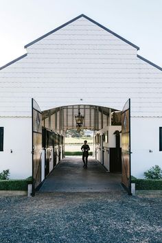 a person walking into a white barn