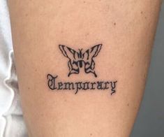 a woman with a tattoo on her leg that says temporary