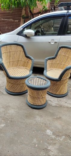 two wicker chairs sitting next to each other in front of a car