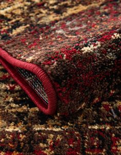 a close up view of a red and brown rug