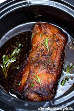 pork roast in the slow cooker with rosemary garnish