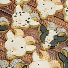 decorated cookies with black and white designs on wooden table next to other cookies in the shape of sheeps