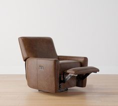 the recliner chair is in front of a white wall and wood flooring,