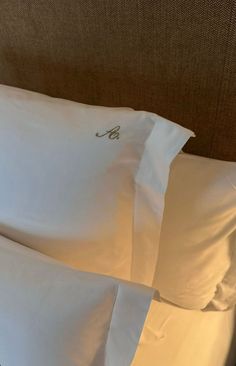 two white pillows sitting next to each other on a bed