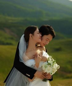 a bride and groom embracing each other in the mountains