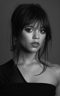 a black and white photo of a woman with long hair wearing a strapless top