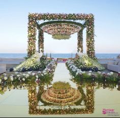 an outdoor ceremony setup with flowers and greenery on the ground, overlooking the ocean