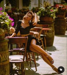 a beautiful woman sitting at a table with her legs crossed in front of her face