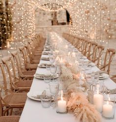 a long table is set with candles and place settings