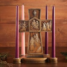 a wooden cross with three candles in front of it