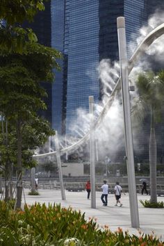 some people are walking around with steam coming out of the pipes in the air behind them