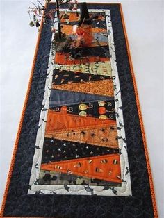 an orange and black table runner with pumpkins on it