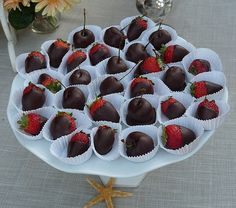 chocolate covered strawberries are arranged on a platter with star shaped strawberries in the middle