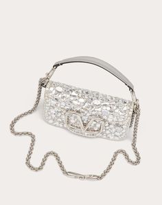 Valentino Garavani Locò small shoulder bag covered in crystals with metallic VLogo Signature detail. Equipped with both a detachable sliding chain strap and a detachable handle, this accessory can be worn as a crossbody/shoulder bag or carried as a handbag. - Palladium-finish hardware - Magnetic closure with logo - Removable leather handle - Shoulder strap with removable sliding chain - Nappa leather lining. Interior: one slip pocket Shoulder strap drop length: 55 cm / 21.6 in. - Dimensions: W20