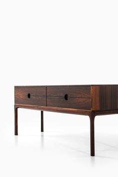 the sideboard has two drawers and is made out of wood, with one drawer open