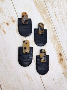 four pieces of black and brown wood with animal prints on them sitting on a white wooden surface