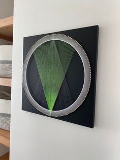 a wall hanging on the side of a white wall with a circular metal object in it