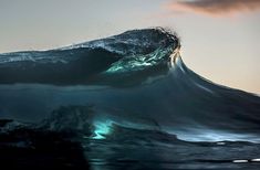 an ocean wave with the sun shining on it