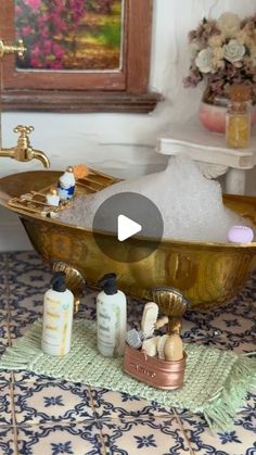 a bathtub filled with lots of soap and lotion sitting on top of a rug