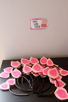 a bunch of pink hearts sitting on top of a black table next to a white wall