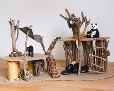 there is a small tree house made out of sticks and logs with animals on it