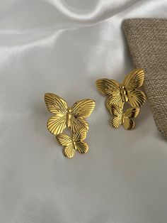 two gold butterflies on a white cloth