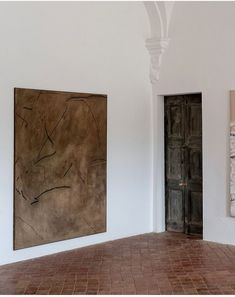 two paintings hang on the wall next to each other in a room with tile flooring