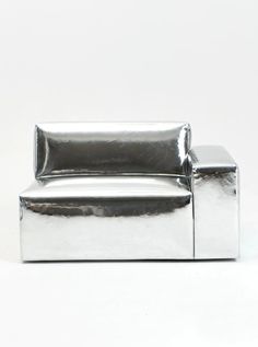 a silver couch sitting on top of a white floor