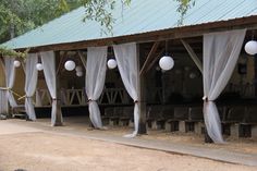 an outdoor venue with white drapes and hanging lanterns