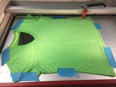 a green t - shirt is being cut into pieces